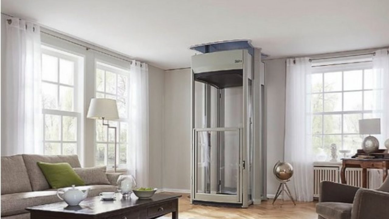 a living room with a home elevator that leads to the second floor