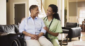 a woman in a wheelchair talking to a in home nurse