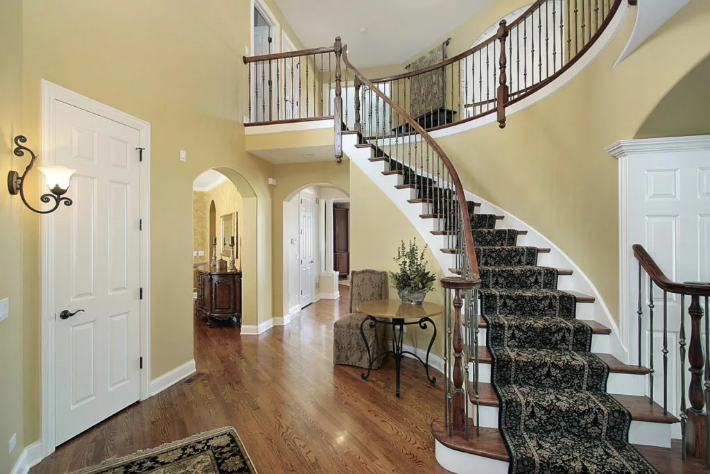 a carpeted staircase in a house with wood floors