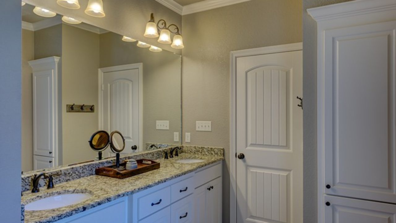 a bathroom with double sinks and two mirrors