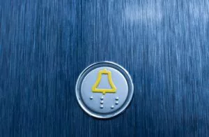 a blue metal surface with a yellow bell on it
