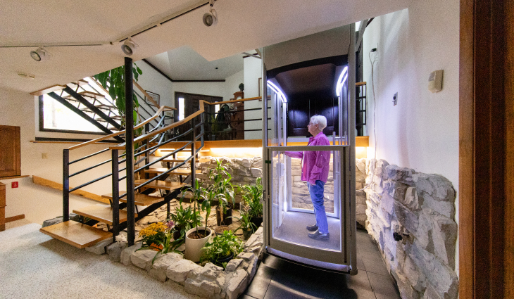 A person in an elevator arriving on the lowest floor of their home