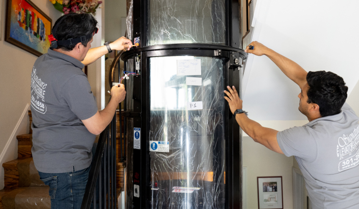 Two technicians installing a home elevator